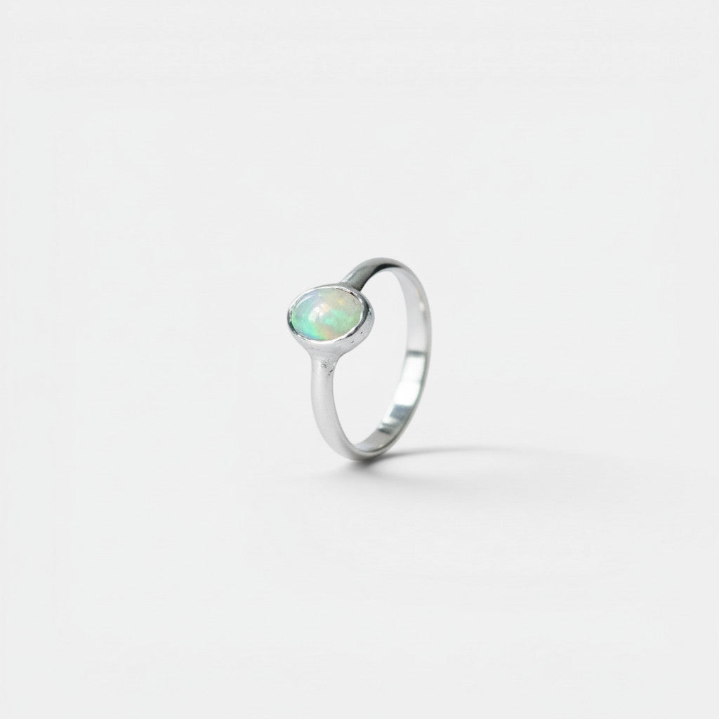 Nooe UG sterling silver ring with oval Ethiopian opal, showcasing iridescent colors. Elegant and timeless.